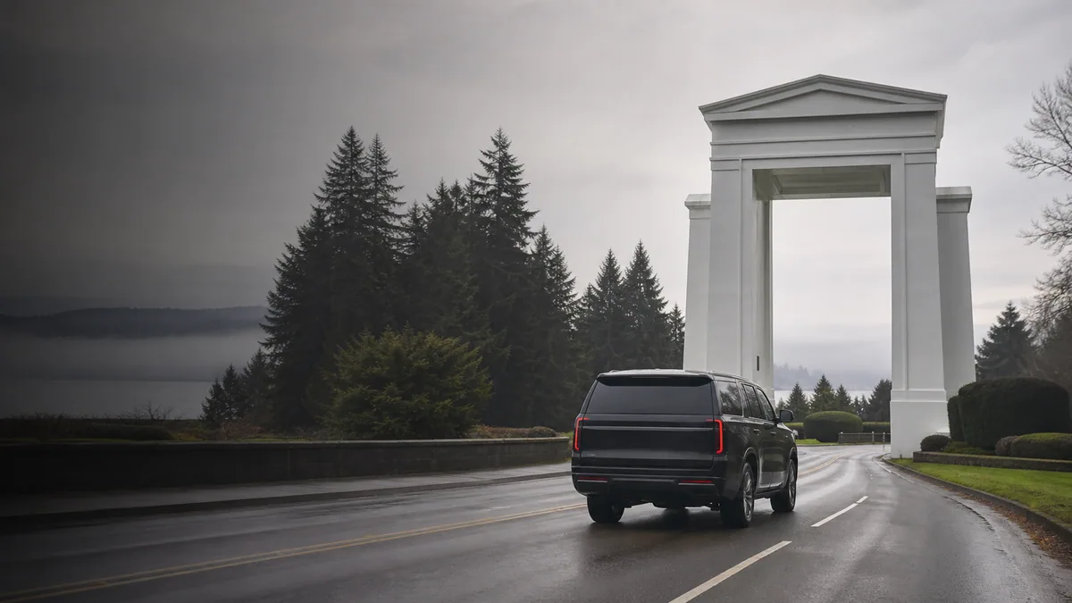 Black executive SUV approaching the Peace Arch crossing on a misty morning